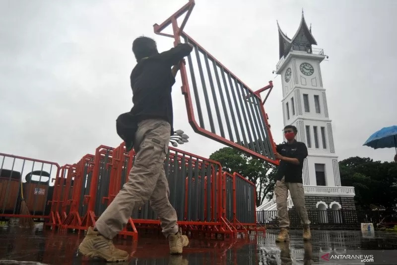 Petugas menyiapkan pagar untuk menutup kawasan pedestrian Jam Gadang, di Bukittinggi, 
Sumbar, Kamis (31/12/2020). 